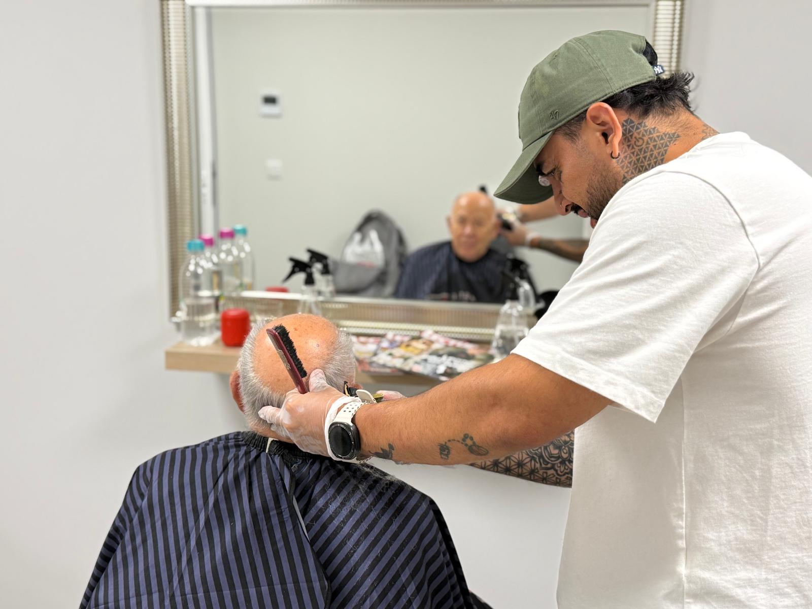 Voluntario de ASIM cortando el pelo a un usuario del proyecto de discapacidad