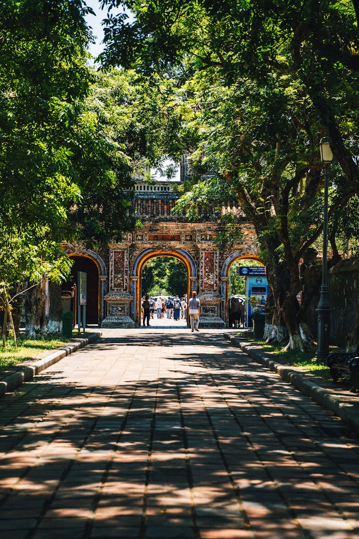 why-choose-us Scenic view of a historic gateway in Huế, Vietnam, surrounded by lush trees.